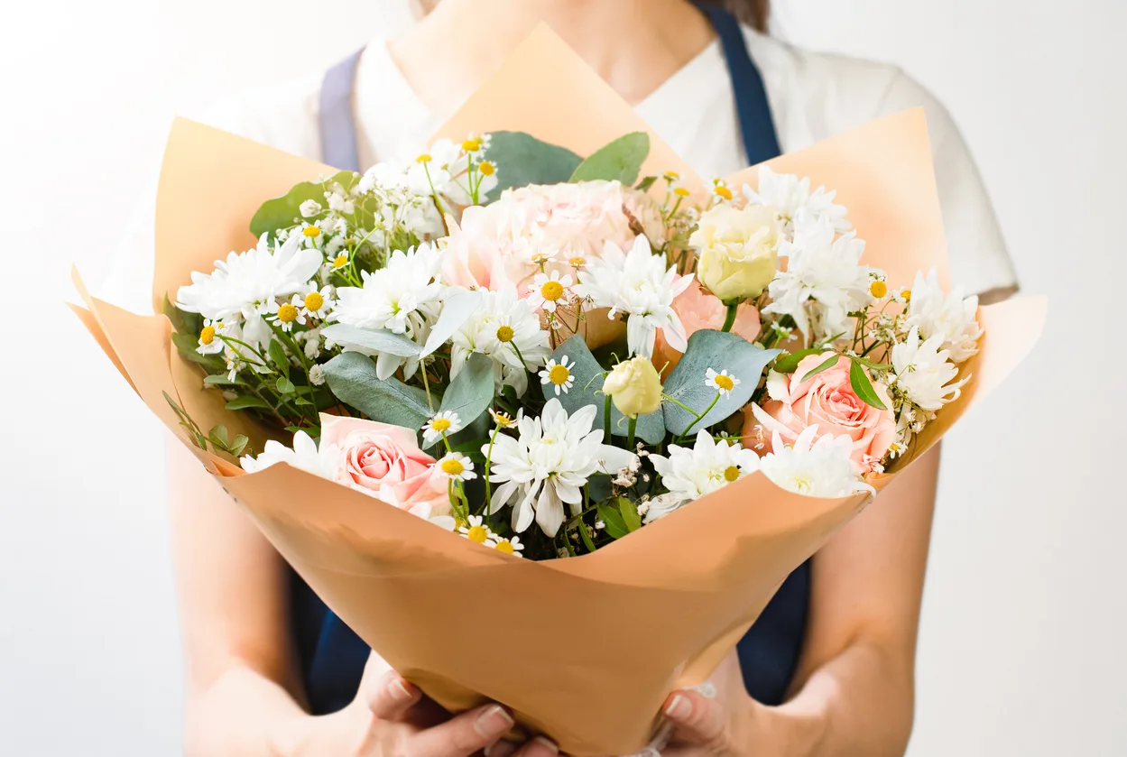 florist with a bouquet of flowers retail floral supplies